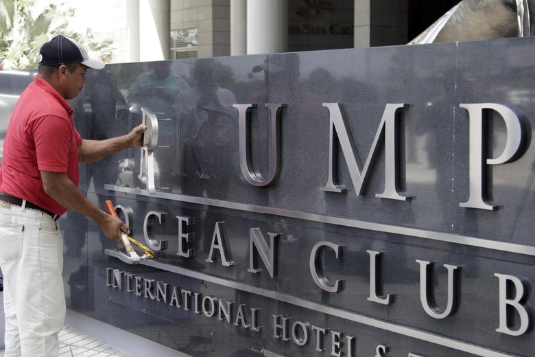 A worker removes the Trump lettering from the sign outside the Trump Hotel in Panama City on Monday after the majority owner of the luxury hotel evicted Trump company employees in a contract dispute.